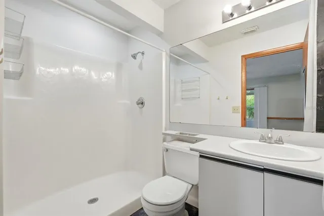a bathroom with a sink a toilet and shower