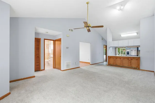 a view of a room with a ceiling fan and window