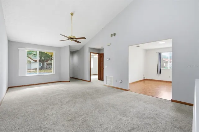 an empty room with a ceiling fan and a window