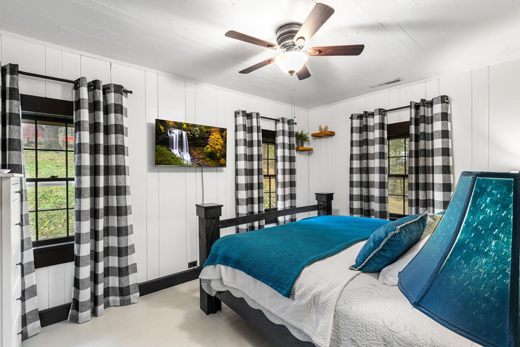 106 Settawig Road Brasstown, NC 28902 - Photo 20 of 100 a bedroom with a bed next to a window with a flat screen tv