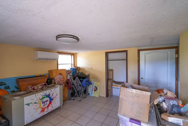 a bedroom with a bed and a lamp on the dresser