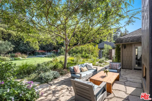 a view of backyard of house with outdoor seating and green space