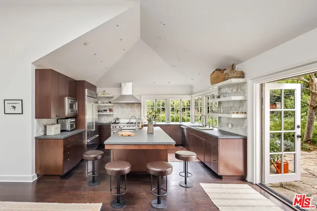 a room with stainless steel appliances kitchen island granite countertop furniture and a large window