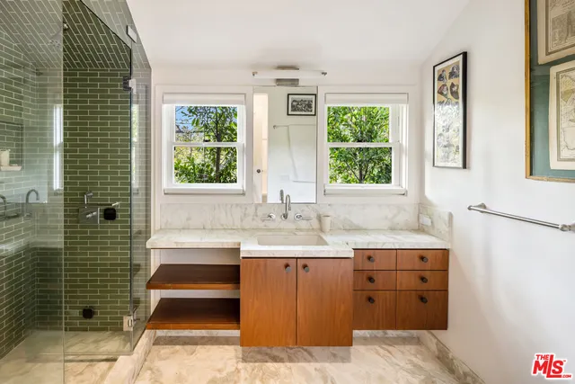 a bathroom with a sink a large mirror and a bathtub next to a window