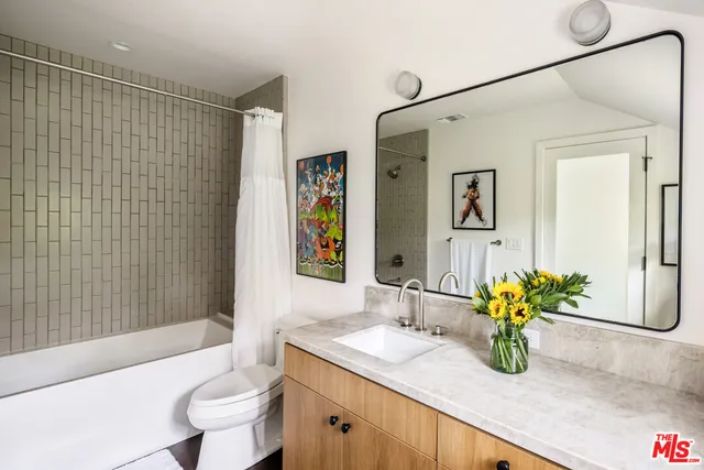 a bathroom with a granite countertop sink a toilet and shower
