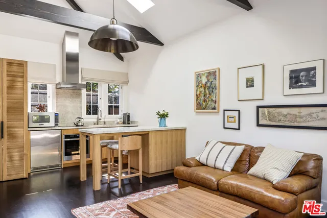 a living room with stainless steel appliances kitchen island granite countertop furniture and a large window