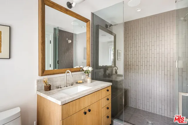 a bathroom with a sink a toilet and mirror