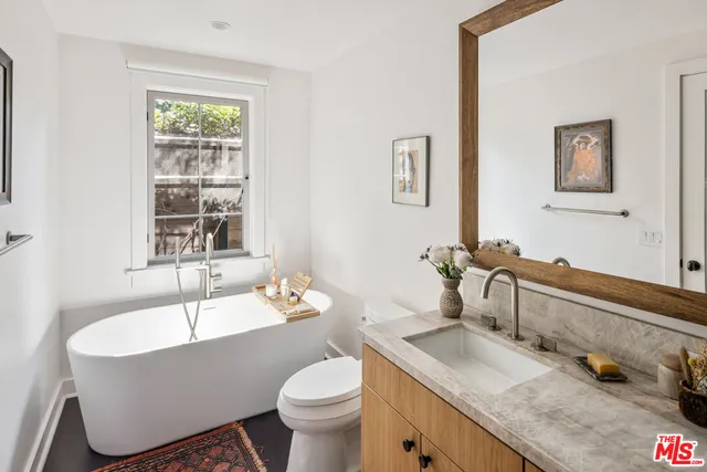 a bathroom with a granite countertop sink and a bathtub