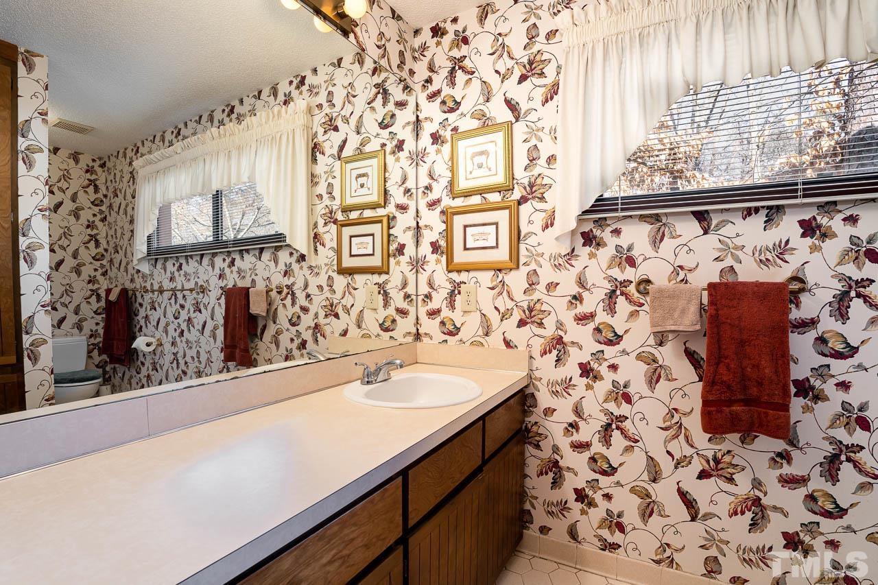 2745 Rue Sans Famille Raleigh, NC 27607 - Photo 11 of 15 a bathroom with a sink and a mirror