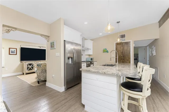 a kitchen with a refrigerator sink and wooden floor