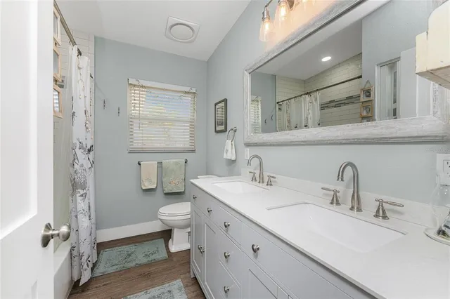 a bathroom with a double vanity sink toilet and a mirror