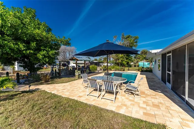 a view of a patio with a dining table and chairs under an umbrella