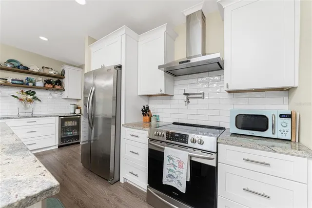 a kitchen with refrigerator a stove and a refrigerator with wooden floor