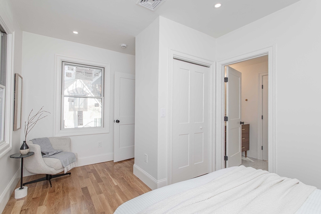125 Mt Vernon Street, Unit 2 Newton, MA 02465 - Photo 24 of 36 a bedroom with a bed and wooden floor
