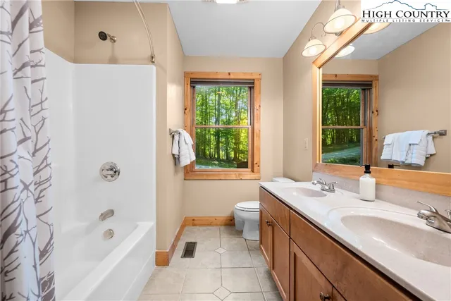a bathroom with a granite countertop sink a mirror bathtub and shower