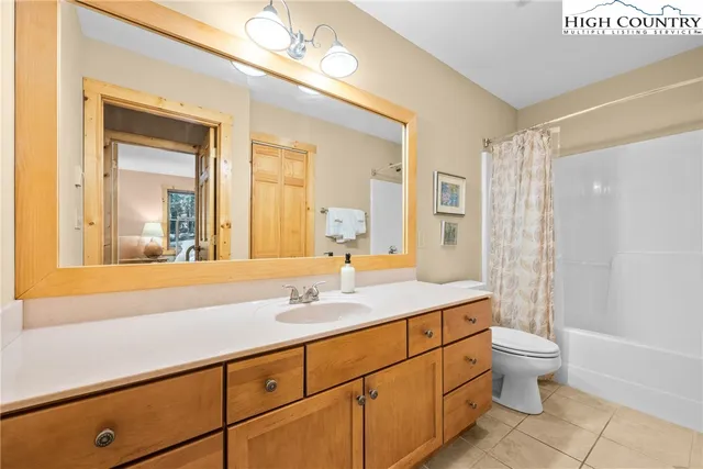 a bathroom with a sink a toilet and a large mirror