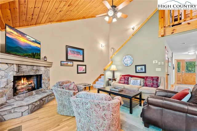 a living room with furniture a flat screen tv and a fireplace