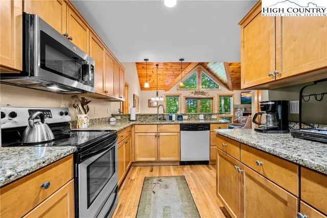 a kitchen with stainless steel appliances granite countertop a sink and a stove