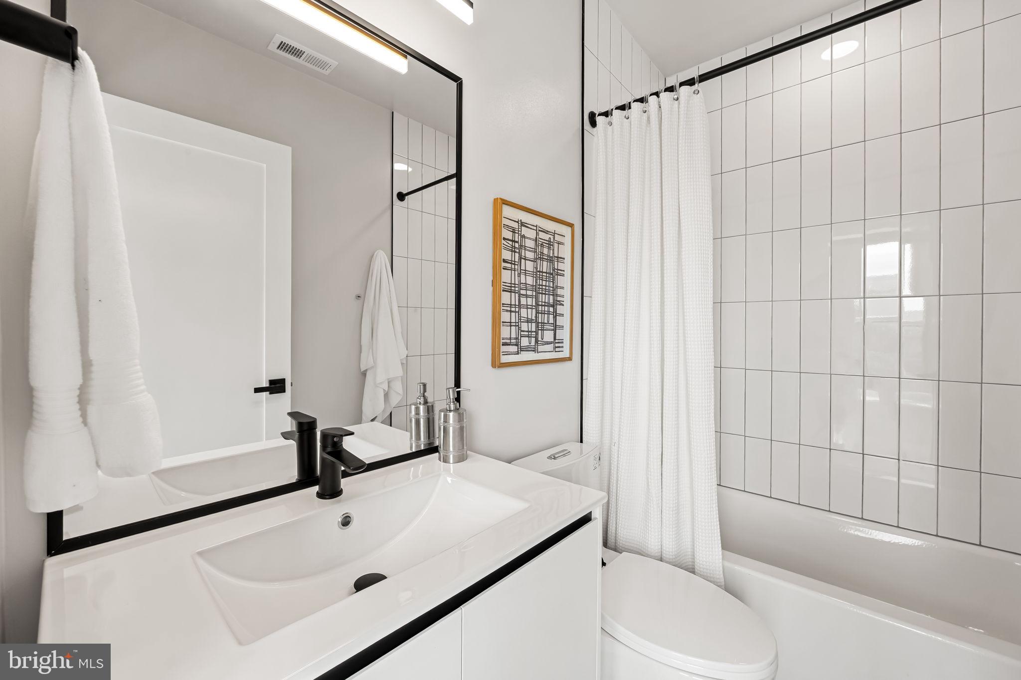 600 North Howard Street, Unit 201 Baltimore, MD 21201 - Photo 17 of 20 a bathroom with a sink toilet and shower