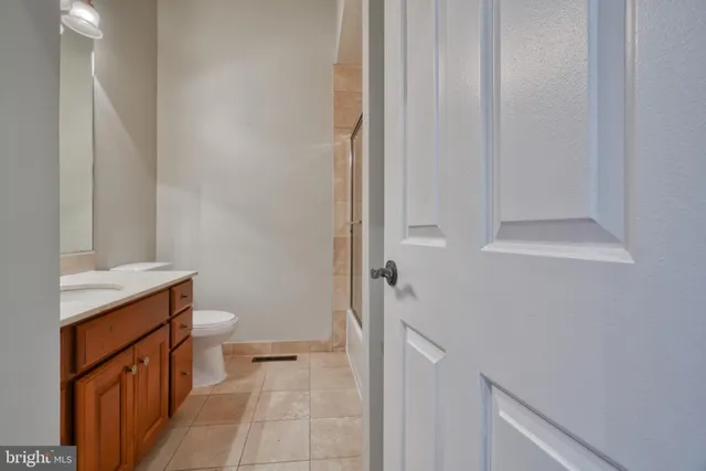 a bathroom with a granite countertop sink and a toilet