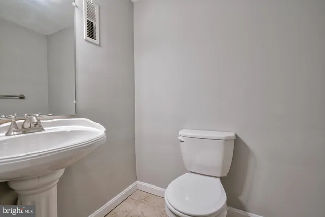 a white toilet sitting next to a bathroom sink