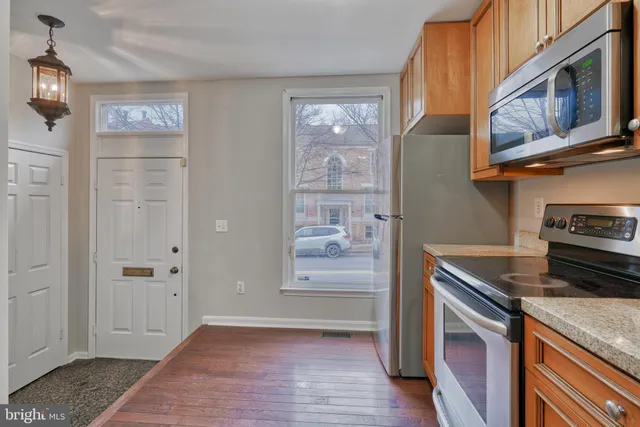 a kitchen with stainless steel appliances granite countertop a refrigerator and a stove top oven