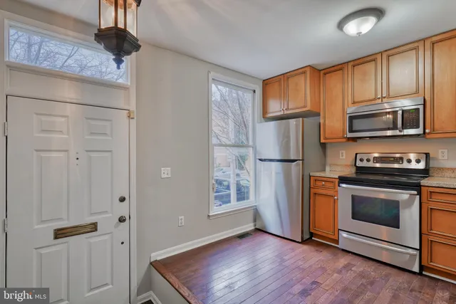 a kitchen with stainless steel appliances granite countertop a refrigerator microwave and stove top oven