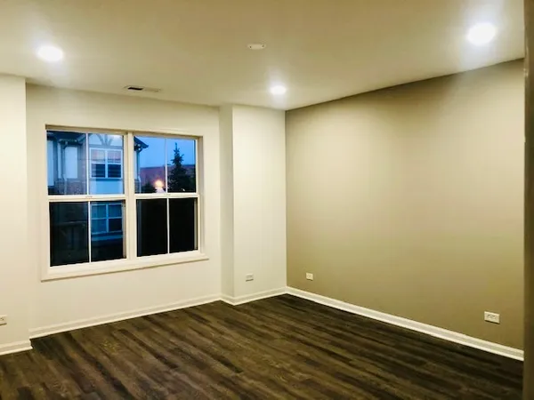 a view of entryway with wooden floor and cabinets
