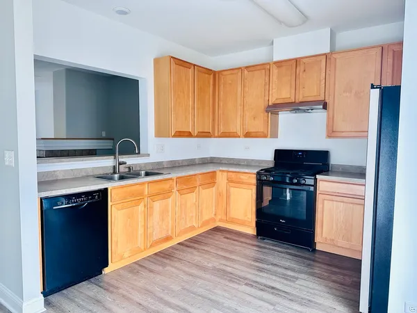 a kitchen with a refrigerator and a stove top oven
