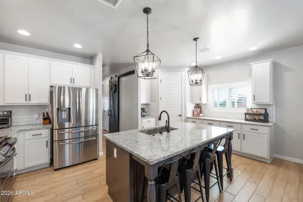 a kitchen with stainless steel appliances granite countertop a kitchen island hardwood floor sink and stove