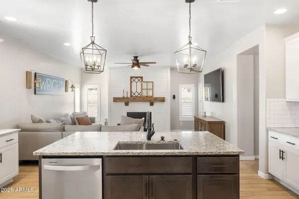 a kitchen with kitchen island granite countertop a sink cabinets and window
