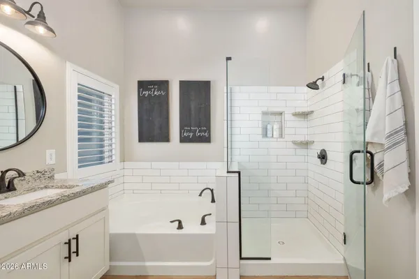a bathroom with a granite countertop sink a mirror and shower