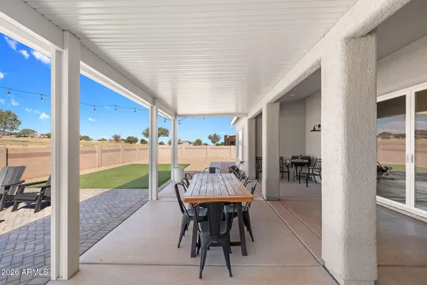 a view of a patio with a table chairs and backyard