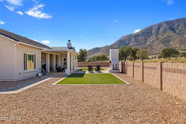 a view of backyard with swimming pool and seating space