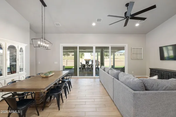 a living room with furniture kitchen view and a chandelier
