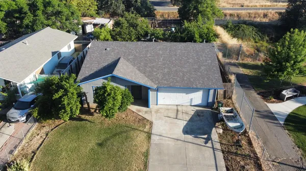 an aerial view of a house with a yard and potted plants