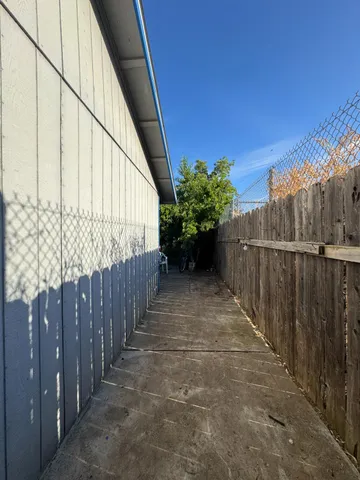 a view of a pathway of a building with wooden fence