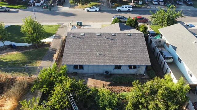 an aerial view of a house with a yard and lake view