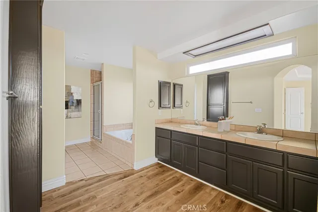 a spacious bathroom with a double vanity sink a mirror and a shower