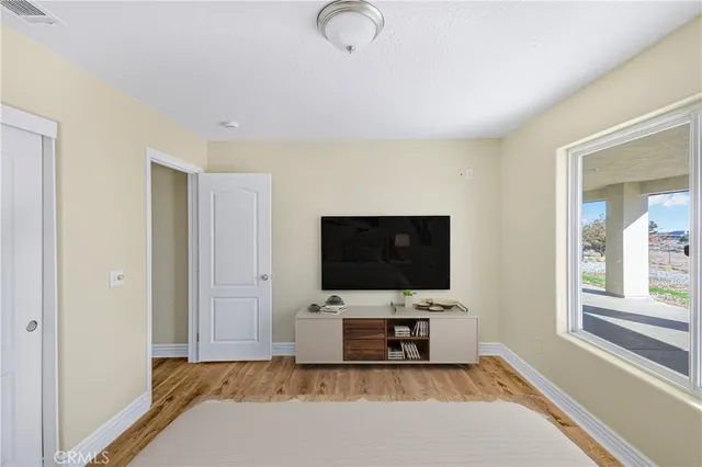 a living room with flat screen tv and a window