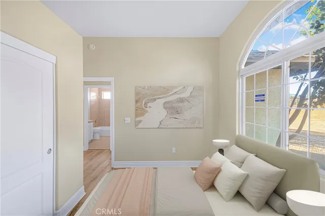 a bedroom with furniture and a large window