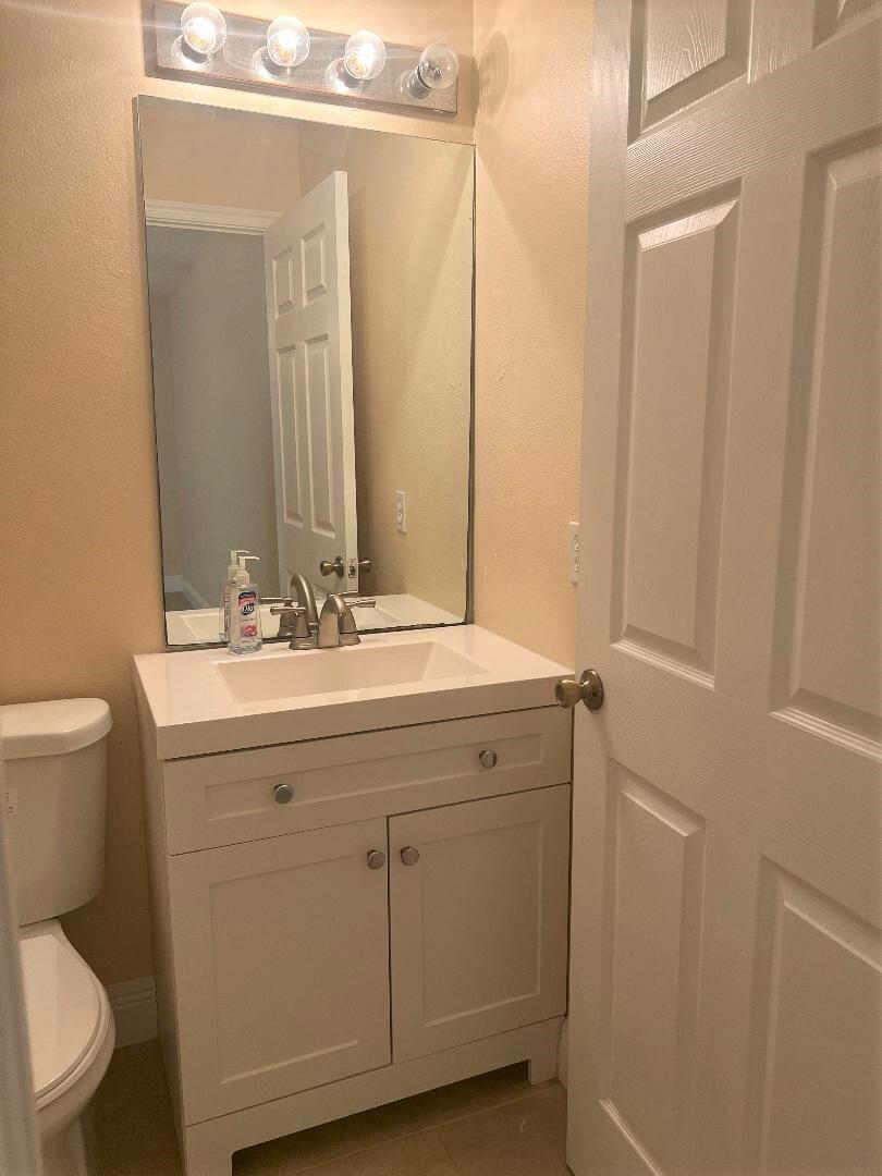 355 Southwest Fairway Avenue Port St. Lucie, FL 34983 - Photo 7 of 8 a bathroom with a sink a toilet and a mirror