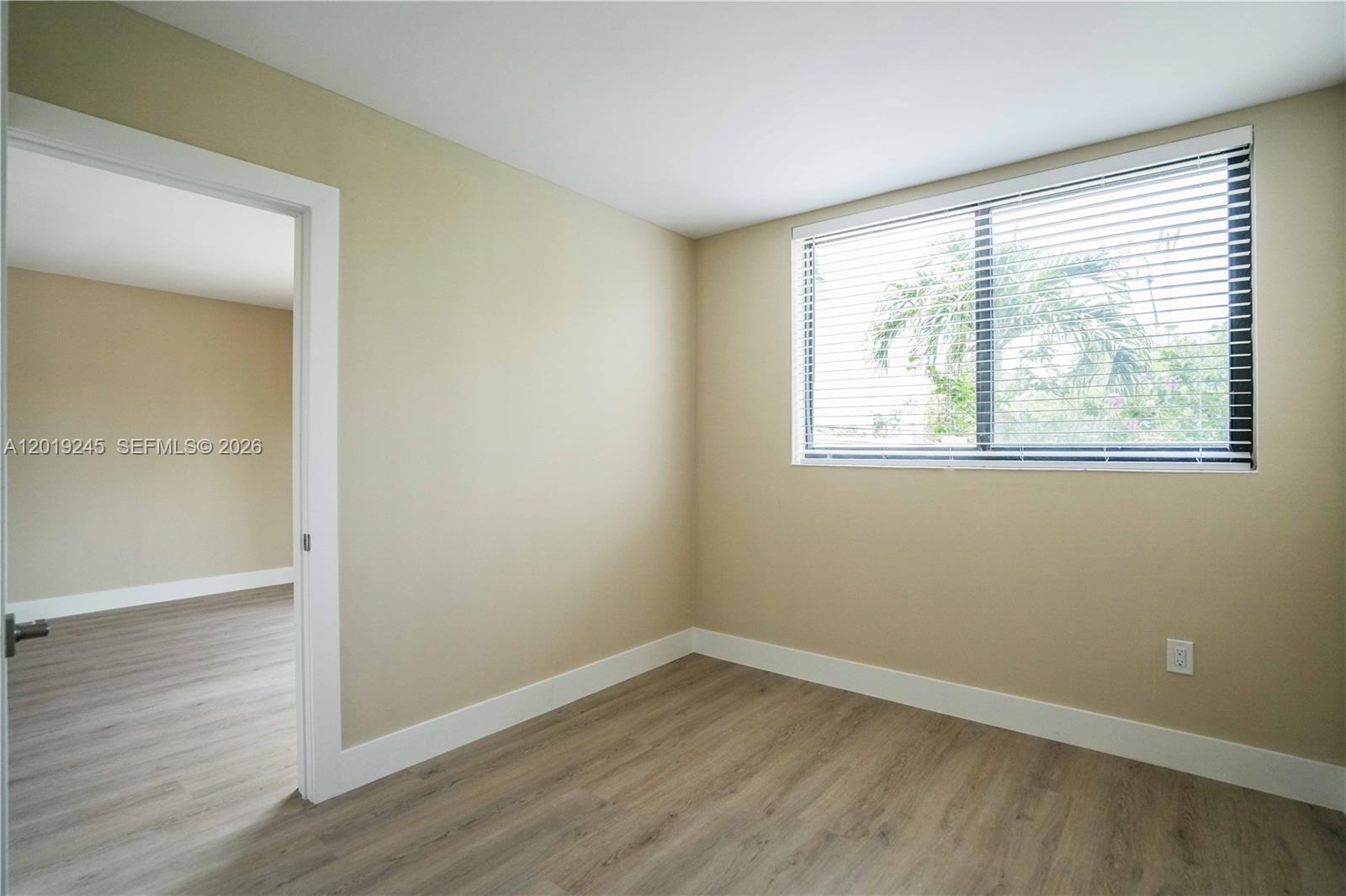 6960 Rue Vendome, Unit 201 Miami Beach, FL 33141 - Photo 13 of 27 an empty room with wooden floor and windows