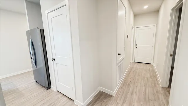 a view of a hallway with wooden floor and staircase