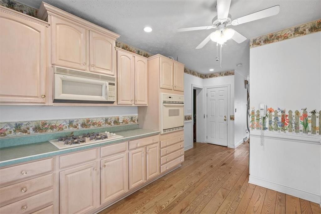 1315 South Main Street Burgettstown, PA 15021 - Photo 15 of 24 a kitchen with stainless steel appliances granite countertop a refrigerator a sink dishwasher and white cabinets with wooden floor