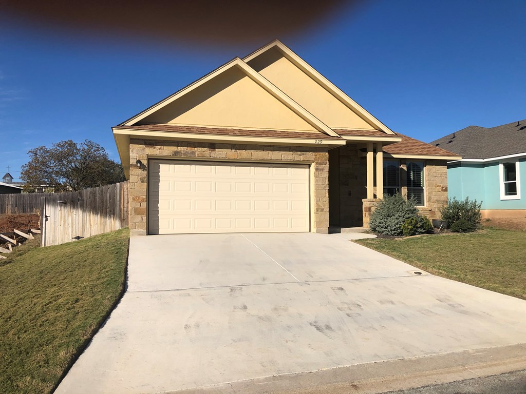 229 Riley Lane Fredericksburg, TX 78624 - Photo 4 of 16 a front view of a house with a yard and garage