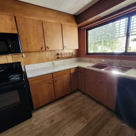 a large kitchen with cabinets and wooden floor