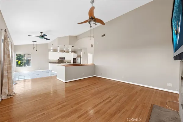 a view of a kitchen with kitchen island white cabinets and stainless steel appliances