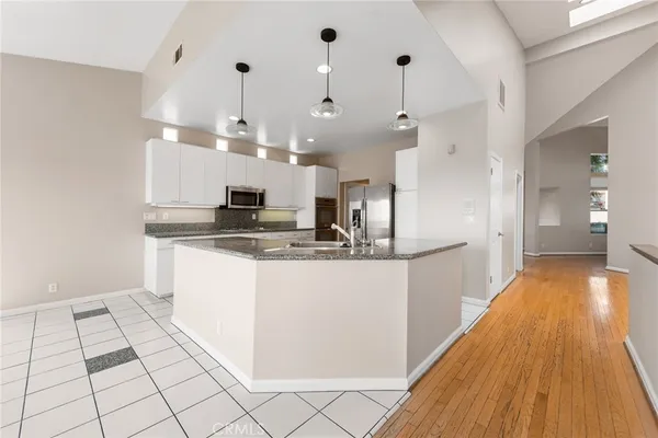 a view of a big room with wooden floor and windows