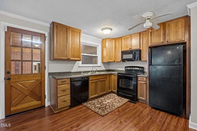 a kitchen with granite countertop wooden floors a stove and a refrigerator